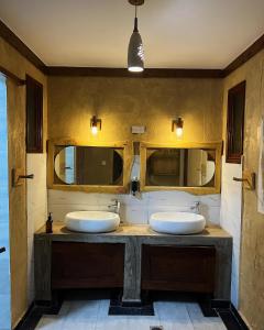 two sinks in a bathroom with two mirrors at Vota Ranch Luxury Stay & Nature Retreat in Machakos