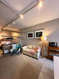 uma sala de estar com um sofá e uma cama em Home Time Studios em Florianópolis