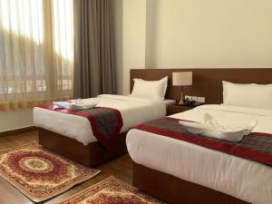 a hotel room with two beds and a window at Hotel pema raga in Thimphu