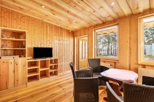 un salon avec une télévision, une table et des chaises dans l'établissement Bungalow 6 - Anglerinsel, à Kollm