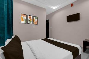 a white bedroom with a bed and a tv at Super Hotel O Kota Railway Junction Formerly Formerly Aagam Inn in Kota