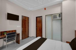 a bedroom with a bed and a desk and a television at Super Hotel O Kota Railway Junction Formerly Formerly Aagam Inn in Kota