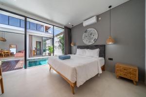 - une chambre avec un grand lit et une piscine dans l'établissement Harmony A29-Peaceful 1BR Retreat, à Seminyak