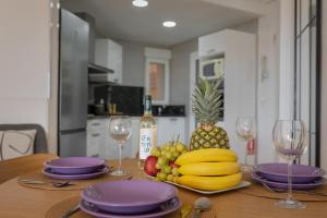 a table with a plate of fruit and wine glasses at Apartament z widokiem na morze Cabo Roig in Orihuela Costa