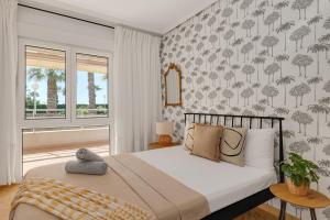 a bedroom with a bed with a palm tree wallpaper at Apartament z widokiem na morze Cabo Roig in Orihuela Costa