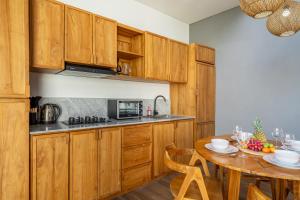 une cuisine avec des armoires en bois et une table en bois dans l'établissement Harmony A29-Peaceful 1BR Retreat, à Seminyak