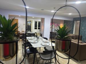 a dining room with tables and chairs and potted plants at Angel Hotels in Lagos