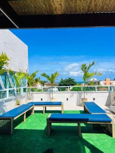 a group of picnic tables on the roof of a building at La Coruña Flat Makaranduba in Porto De Galinhas