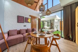 - un salon avec une table et un canapé violet dans l'établissement Harmony A29-Peaceful 1BR Retreat, à Seminyak