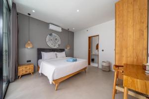 une chambre avec un grand lit blanc et une table dans l'établissement Harmony A29-Peaceful 1BR Retreat, à Seminyak 15 autres photos