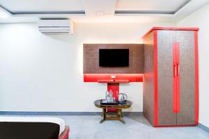 Super Townhouse Lake Town Clock Tower Formerly Crown Comfort في Pātipukur: غرفة بها تلفزيون وأريكة وطاولة +23 صورة