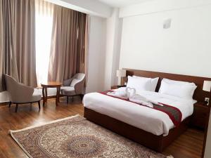 a hotel room with a large bed and a chair at Hotel pema raga in Thimphu +34 photos