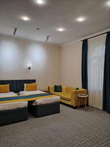 una habitación de hotel con dos camas y un sofá en Pera Hotel Baku, en Baku