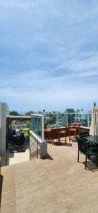 a patio with tables and chairs on a roof at La Coruña Flat Makaranduba in Porto De Galinhas
