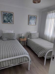 a bedroom with two beds and a night stand at Stay Breezy in Erowal Bay
