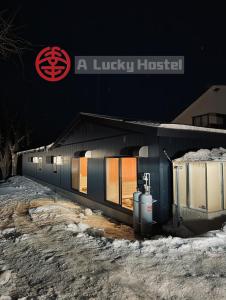 Un edificio con un cartel al costado. en A Lucky Hostel, en Hakuba
