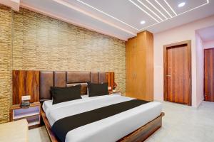 Un dormitorio con una cama grande y una pared de ladrillo. en Townhouse Oak Panki Railway Junction Formerly Hotel Rudra, en Kaliānpur