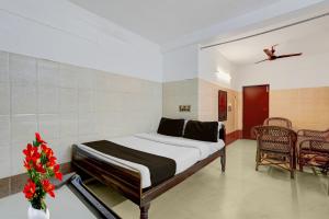 um quarto com uma cama, uma mesa e cadeiras em Hotel O Rock Beachview Pondicherry Formerly Varsha Residency em Pondicherry