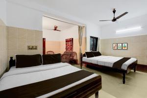 um quarto com duas camas e uma sala de estar em Hotel O Rock Beachview Pondicherry Formerly Varsha Residency em Pondicherry