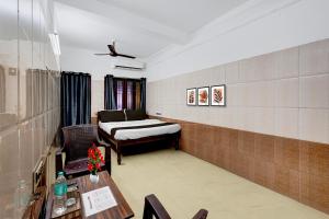 um quarto com uma cama, uma escrivaninha e uma mesa em Hotel O Rock Beachview Pondicherry Formerly Varsha Residency em Pondicherry