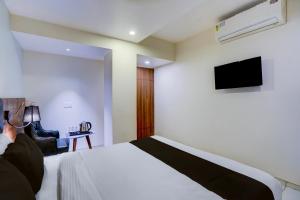 Una televisión o centro de entretenimiento en Townhouse Vadodara Railway Junction Formerly Hotel Unique 23 fotos más