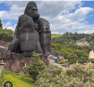 una grande statua di pietra su una collina con alberi di O Casarão a Cotia
