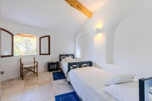 duas camas em um quarto branco com janela em Apartment In Porto Cervo em Porto Cervo mais 37 fotografias