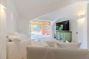 uma sala de estar branca com um sofá e uma televisão em Apartment In Porto Cervo em Porto Cervo