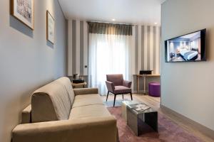 a living room with a couch and a chair at Hôtel Magellan in Paris