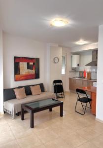 una sala de estar con un sofá y una mesa en Apartamento poleo, en Benalmádena