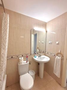 Un baño con lavabo, inodoro y espejo. en Apartamento poleo, en Benalmádena
