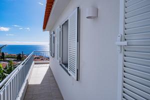 a balcony of a house with a view of the ocean at Villa Infinityviews Madeira in Câmara de Lobos +34 photos
