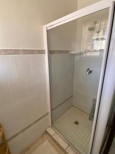 een douche met een glazen deur in een badkamer bij Highway Haven in Stilfontein