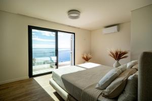 una camera da letto con un letto e una grande finestra di Villa Infinityviews Madeira a Câmara de Lobos Altre 27 foto