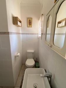een witte badkamer met een toilet en een wastafel bij Highway Haven in Stilfontein
