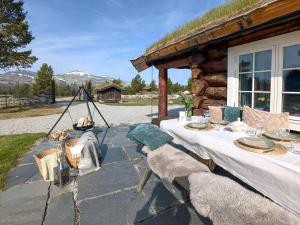 a table and chairs sitting on a stone patio at Modern Hand-Crafted Log Cabin in Dovreskogen