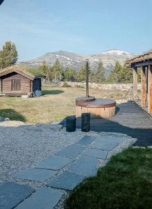 a stone walkway leading to a building with mountains in the background at Modern Hand-Crafted Log Cabin in Dovreskogen +11 photos
