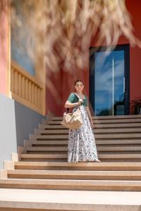 a woman standing on the stairs of a building at Costiero Elegant Suite Gallipoli Mare in Gallipoli