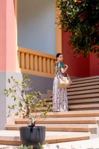 a woman standing on the stairs of a building at Costiero Elegant Suite Gallipoli Mare in Gallipoli