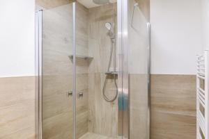 une douche avec une porte en verre dans une salle de bain dans l'établissement Ferienwohnung Paula, à Platzl 25 autres photos