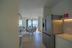 una cucina e una sala da pranzo con tavolo e frigorifero di Villa Infinityviews Madeira a Câmara de Lobos