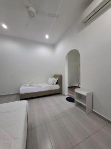 Guesthouse Sungai Musoh في بينجرانج: غرفة بيضاء مع سرير وطاولة