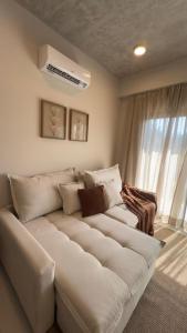 um sofá branco numa sala de estar com uma janela em Edificio Zuba 11 Hermoso Apartamento de 2 Habitaciones en Encarnacion! em Caña de Castilla mais 16 fotografias