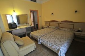 a bedroom with a bed and a couch and a television at Ilis Hotel in Olympia
