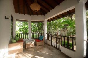 a porch with chairs and a balcony with trees at Harmony Beach Hotel - Tangalle in Tangalle