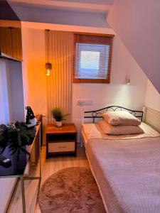una piccola camera da letto con un letto e una finestra di Domek za rzeką a Zawoja