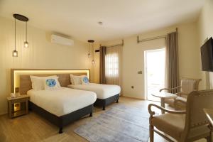 a hotel room with two beds and a chair at Manzara Boutique Hotel - Adults Only in Bodrum City +95 photos