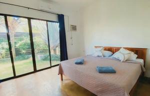 een slaapkamer met een bed met twee blauwe handdoeken erop bij Villas Flora Bella Resort in Dauis +7 foto's