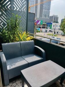 Un banco y una mesa en un balcón. en Angel Hotels, en Lagos
