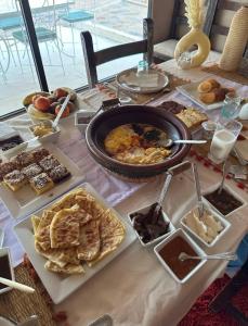 ein Tisch mit einer Reihe von verschiedenen Arten von Lebensmitteln in der Unterkunft Starlit Luxury Camp in Merzouga